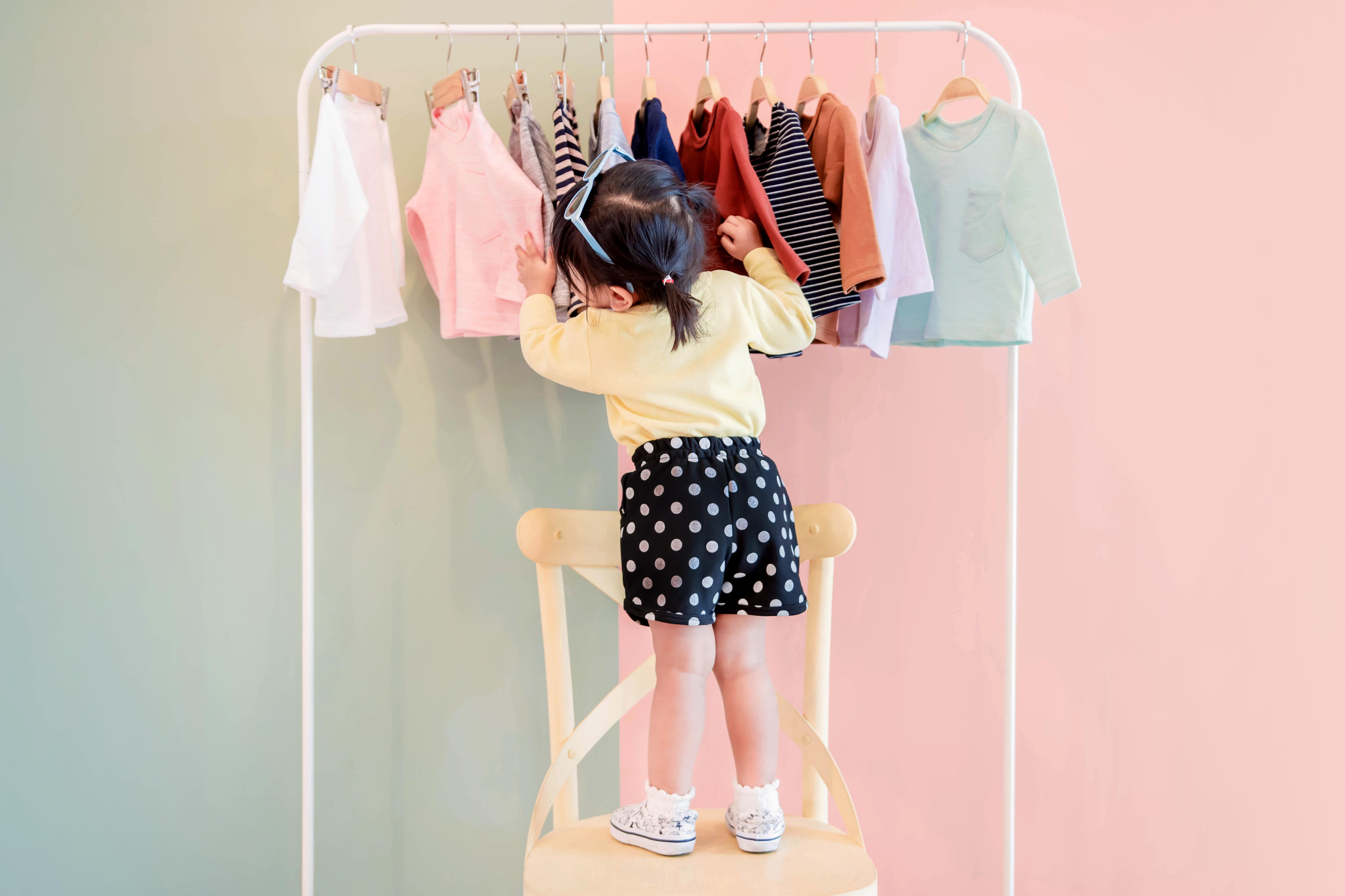 Little girl choosing a shirt